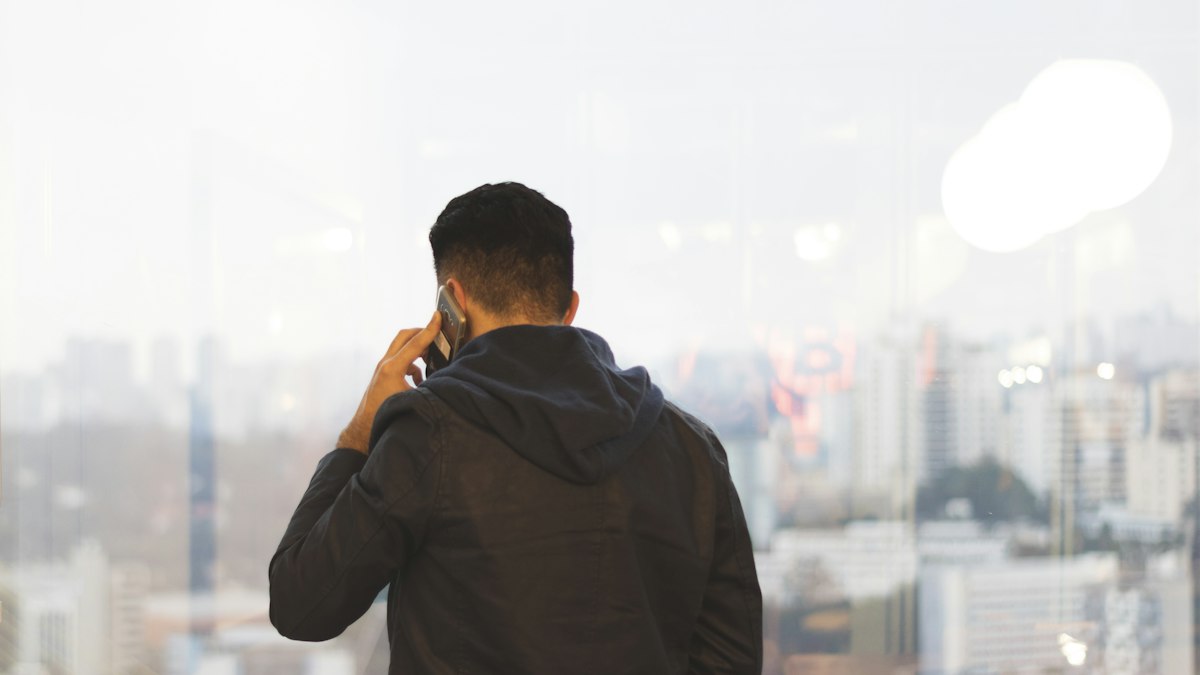 Man making a phone call by a city window