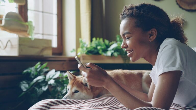 Young woman smiling at her phone at home